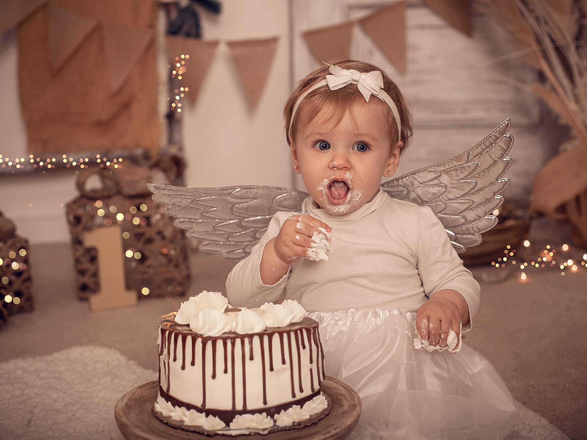 Fotografía smash cake 1 año con alas de ángel